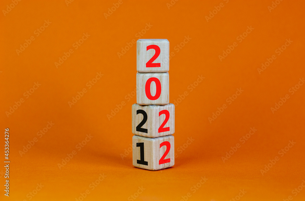 2022 happy new year symbol. Turned cubes, symbolize the change from 2021 to the new year 2022. Beautiful orange background. Copy space. Business and 2022 happy new year concept. 2022 happy new year symbol. Turned cubes, symbolize the change from 2021 to the new year 2022. Beautiful orange background. Copy space. Business and 2022 happy new year concept.
