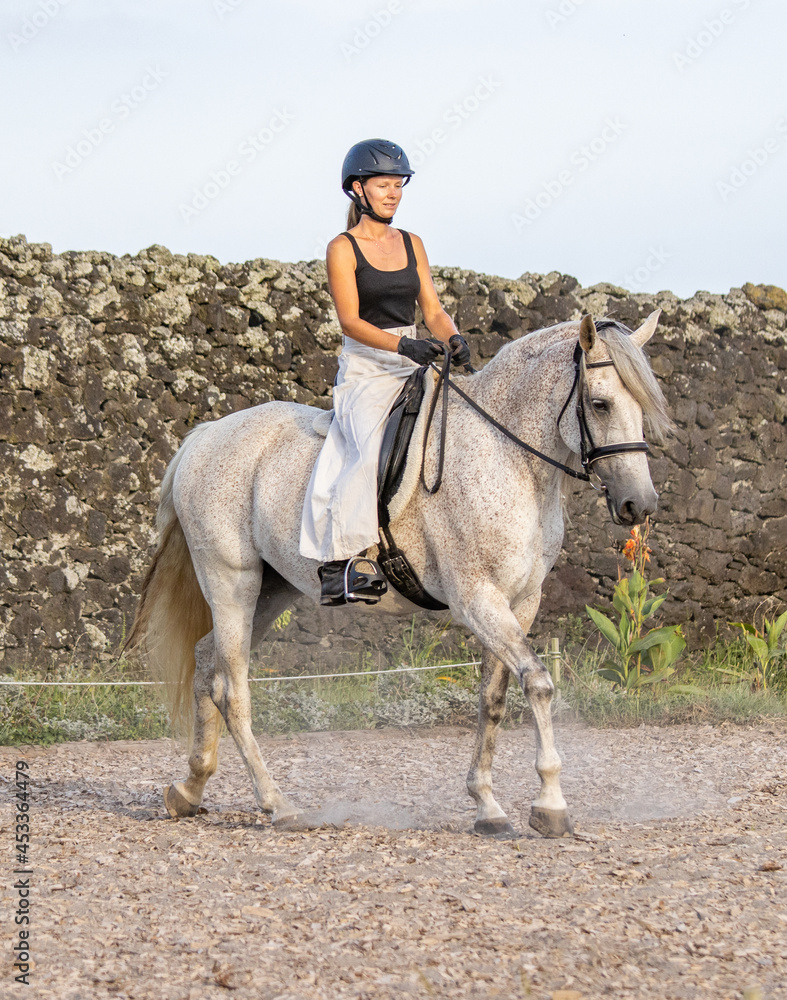 Riding white Lusitano horse, outdoors, cute team, riding arena outside. Riding white Lusitano horse, outdoors, cute team, riding arena outside.