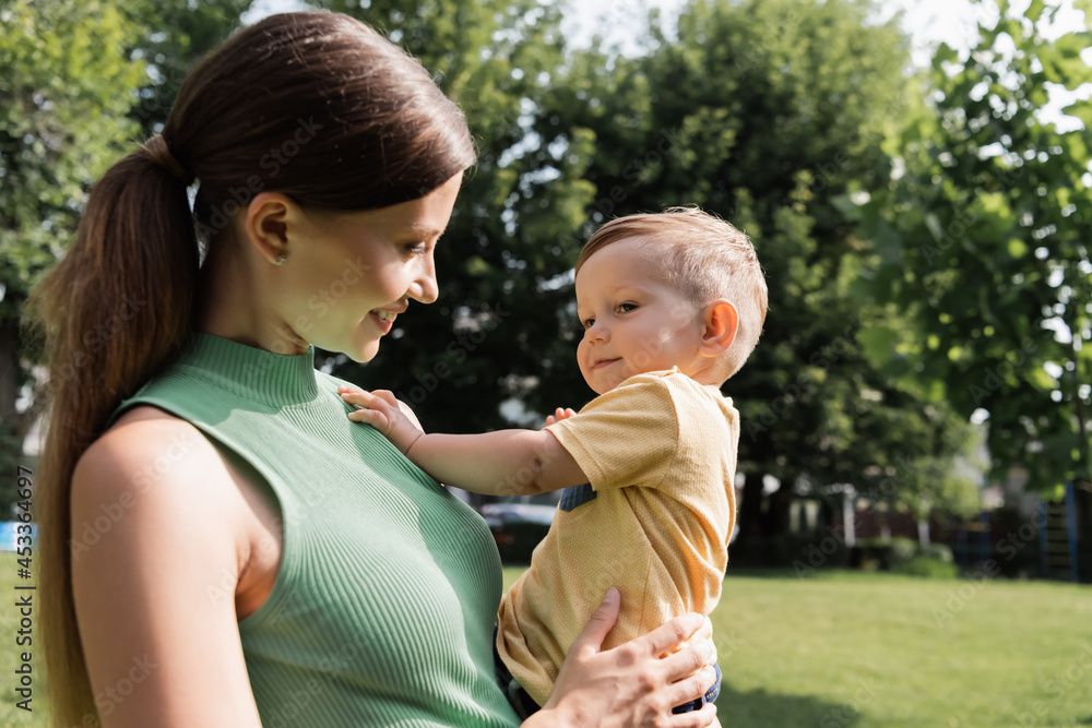 cheerful young mother holding in arms happy toddler son cheerful young mother holding in arms happy toddler son
