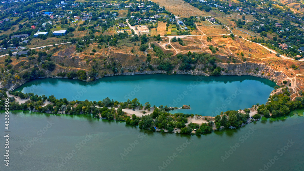 Aerial view over beautiful suburb with a wide river with privat houses. Top view over a people settlement near water...