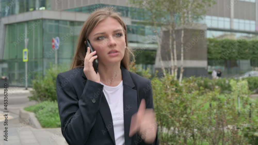 Angry Businesswoman Talking on Phone while Walking on the Street Angry Businesswoman Talking on Phone while Walking on the Street