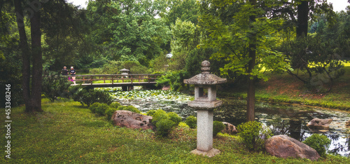 a japanese garden with a bridge and a sculpture