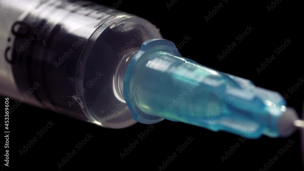 Macro Shot of Syringe with Vaccine Solution On Black Background. Syringe Filling with Liquid Medication Solution Macro Shot of Syringe with Vaccine Solution On Black Background. Syringe Filling with Liquid Medication Solution