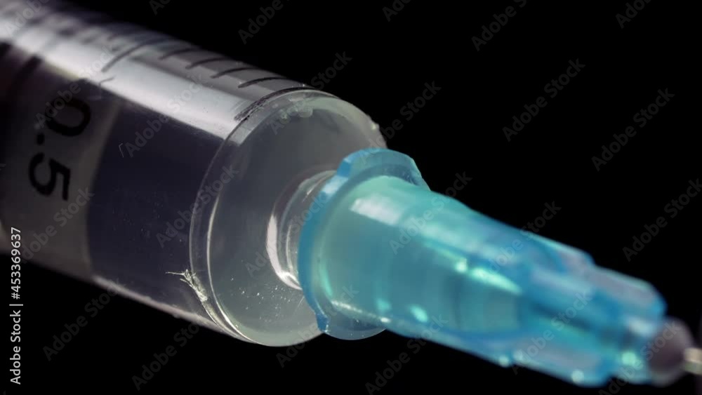 Macro Shot of Syringe with Vaccine Solution On Black Background. Syringe Filling with Liquid Medication Solution Macro Shot of Syringe with Vaccine Solution On Black Background. Syringe Filling with Liquid Medication Solution