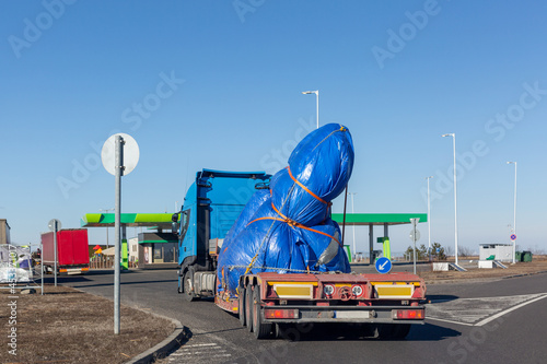 Blue truck with special semi-trailer for oversized loads transportation. Oversize load on flatbed trailer photo