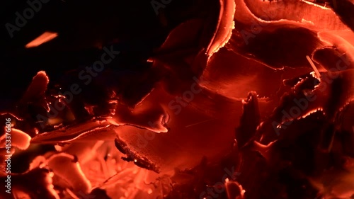 Close-up of a burning campfire, night bonfire, logs, plywood and fabric are on fire, a gust of wind blows up sparks, slo-mo HD video