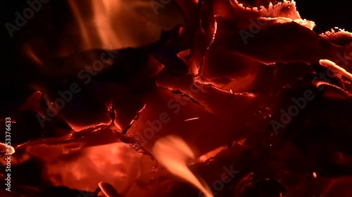 Close-up of a burning campfire, night bonfire, logs, plywood and fabric are on fire, a gust of wind blows up sparks, slo-mo HD video