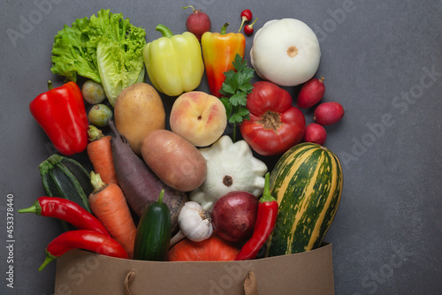 Healthy food background. Healthy vegan vegetarian food in paper bag vegetables and fruits on gray  copy space  banner. Shopping food supermarket and clean vegan eating concept.