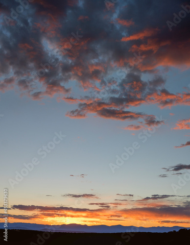 Fotografía Southwest Sunset over Distant Mountains with Dark Orange Clouds