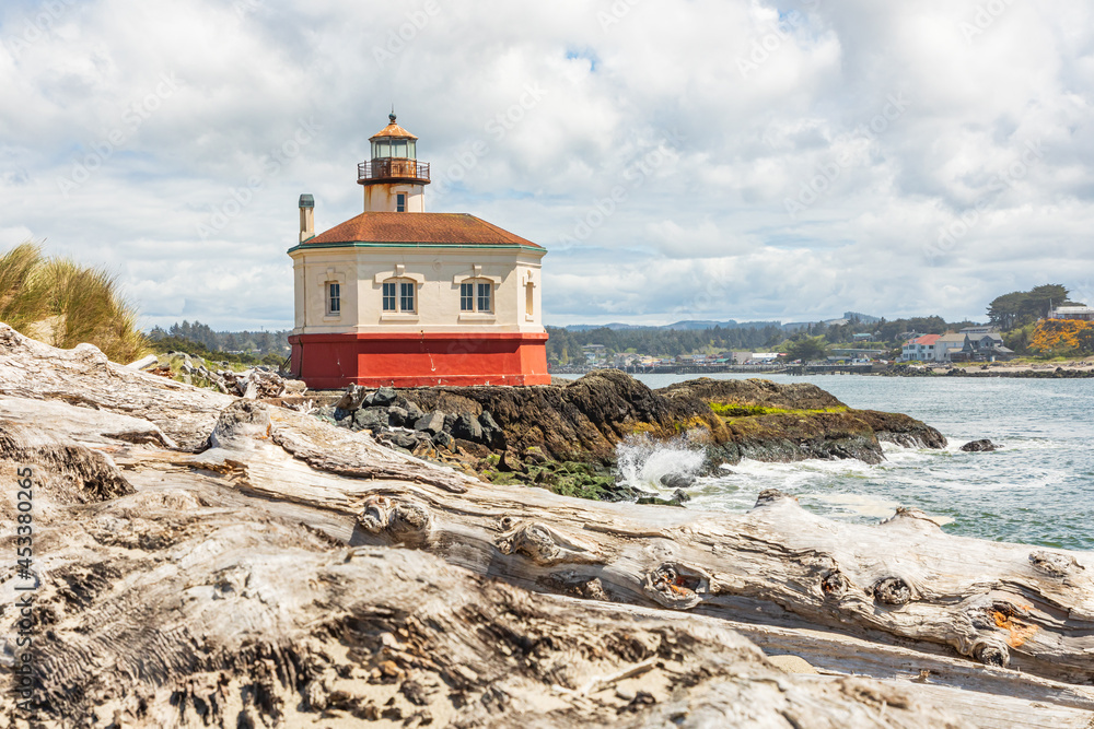 Beach logs and the Coquille River Lighthouse on the Oregon coast.