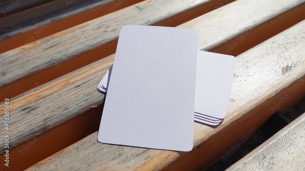 Blank playing card mock up. Deck of white cards on a wooden background Blank playing card mock up. Deck of white cards on a wooden background