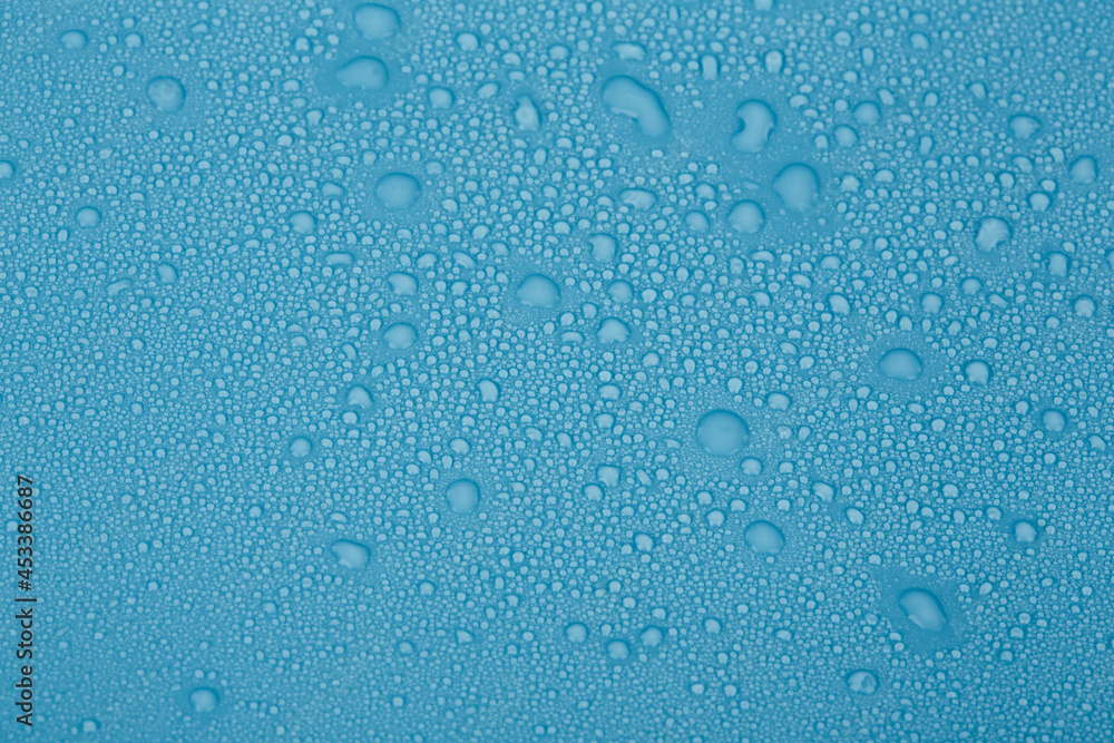 Large and small drops of water on a blue background