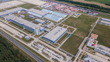 Modern exterior of industrial complex at daytime. Aerial view of manufacturing structure with parking for machinery outdoors. Industrial concept.