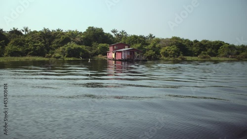 Floating house at amazon river with flying birds