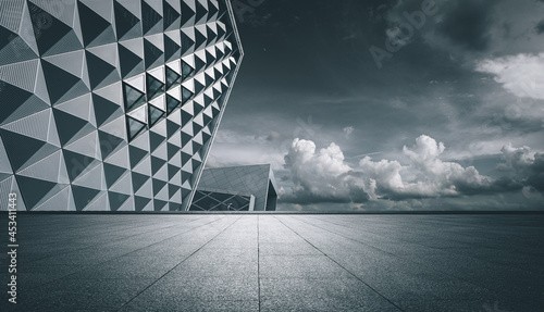 Under the clear sky, the city center buildings behind the stone square