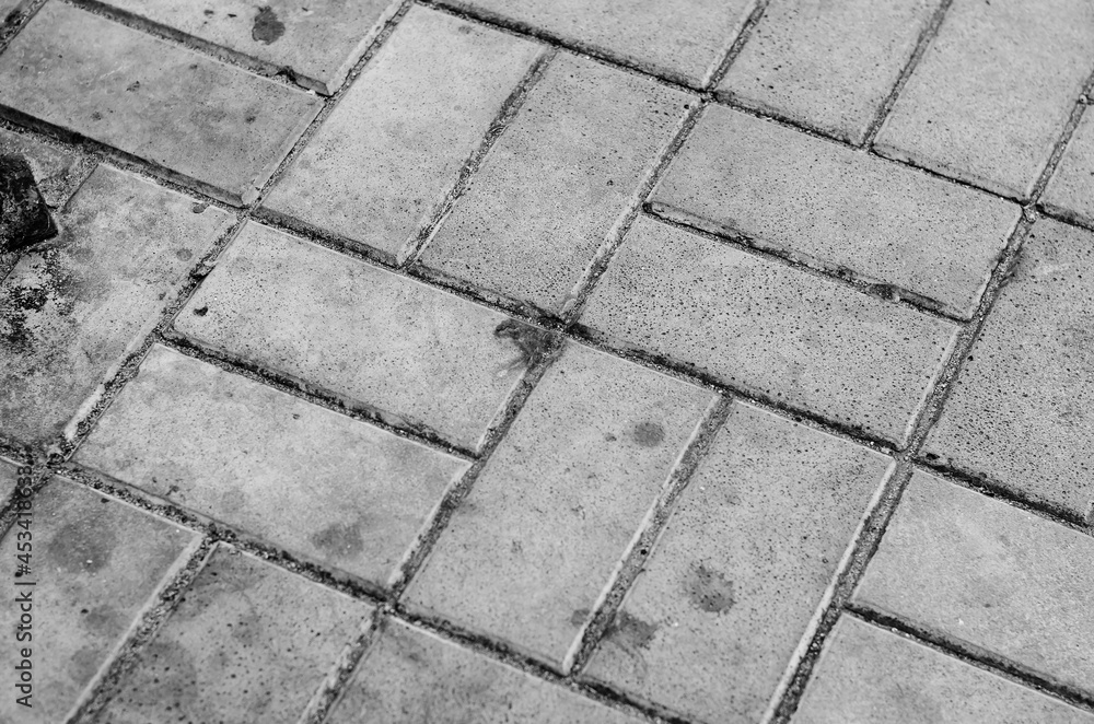 Dirty Sidewalk covered with gray pentahedral tiles. Geometric co