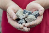 The man holds the rubble in his palms. Pieces of random granite