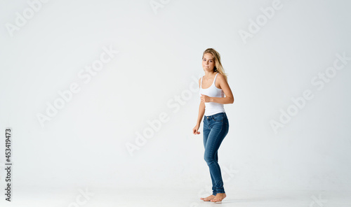 woman in jeans barefoot stands on the floor fashion emotions motion
