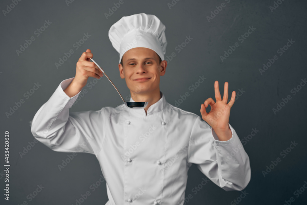 chef with a ladle in his hands is trying dishes restaurant professional