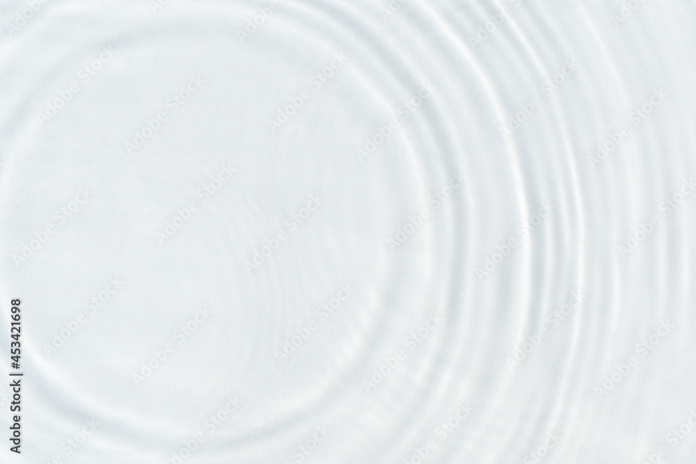 Water droplets fall on the transparent surface of the water in sunlight. Top view, flat lay Water droplets fall on the transparent surface of the water in sunlight. Top view, flat lay