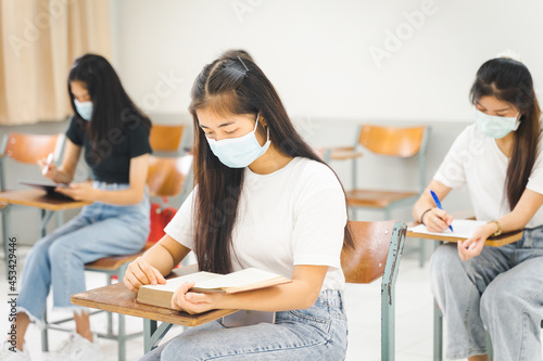 Asian college students back to school with facemask and keep social distance while study in the classroom to prevent COVID-19 pandemic