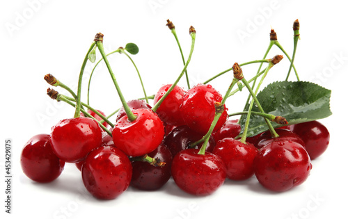 Pile of fresh ripe cherries with water drops on white background