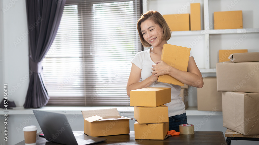 Young Women happy after new order from customer, business owner working at home office packaging on background. online shopping SME entrepreneur or freelance working concept Young Women happy after new order from customer, business owner working at home office packaging on background. online shopping SME entrepreneur or freelance working concept