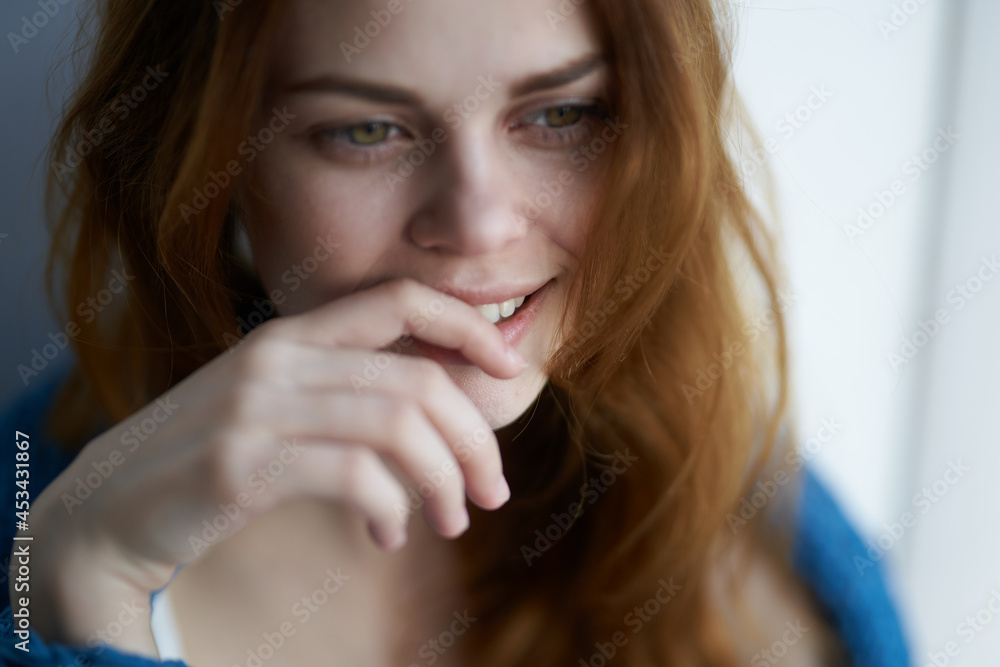 pretty woman sitting near the window with a blue plaid smile at home pretty woman sitting near the window with a blue plaid smile at home