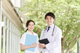 緑背景で笑顔で立つ医師と看護師