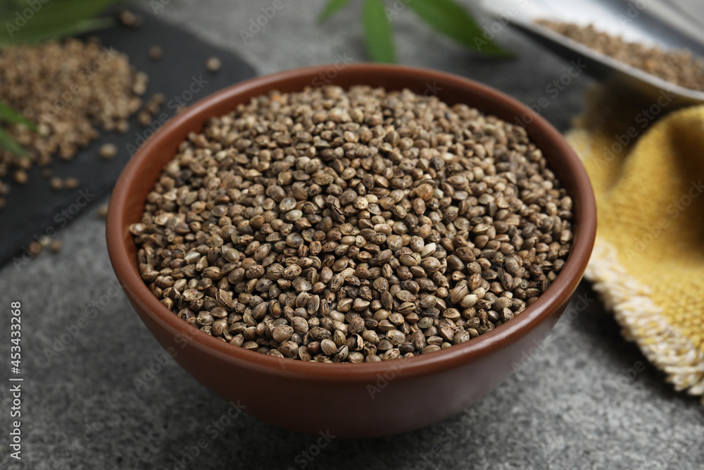 Bowl with hemp seeds on grey table Bowl with hemp seeds on grey table