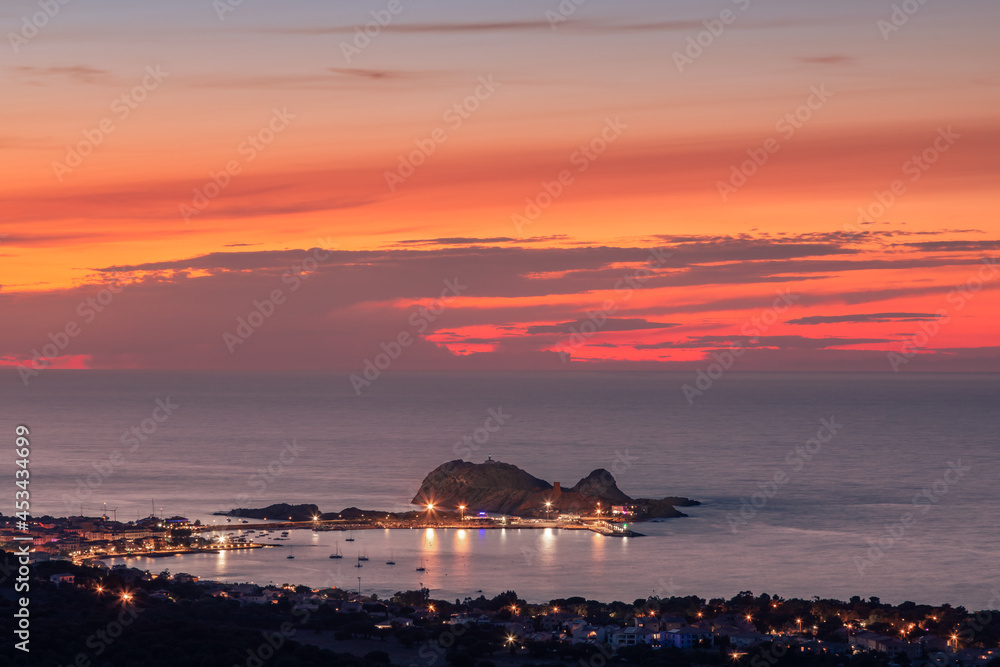 Sun setting over La Pietra at in the Mediterranean sea at Ile Rousse in the Balagne region of Corsica