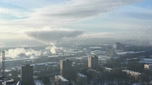 Time lapse of aerial view of industrial and residential districts with vapouring heating plant in hazy winter day photo