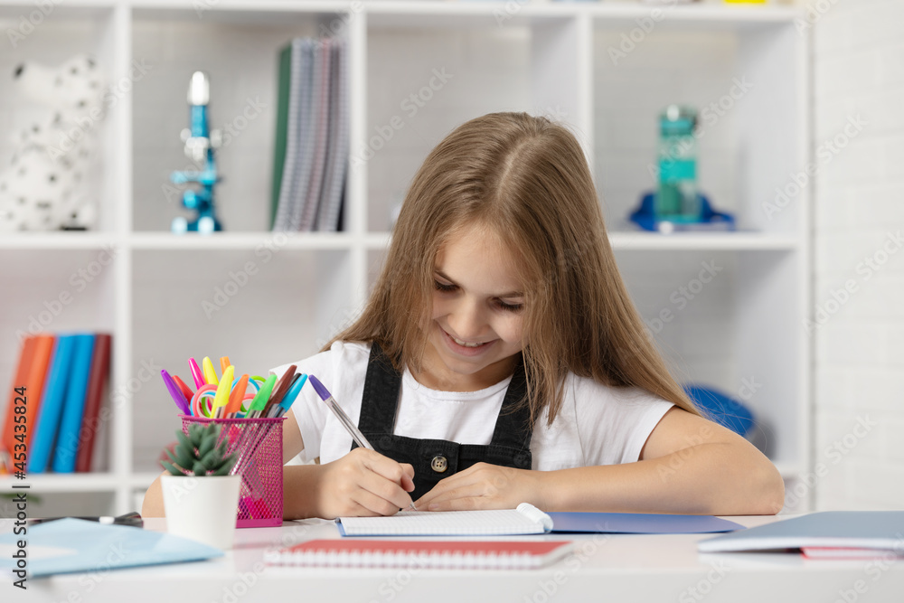 happy child writing in copybook at school lesson in classroom wear uniform, back to school happy child writing in copybook at school lesson in classroom wear uniform, back to school