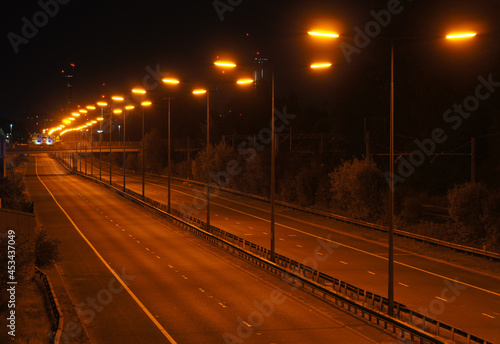 Motorway, freeway or highway at night with orange sodium street lighting. M602, England, UK. No traffic.