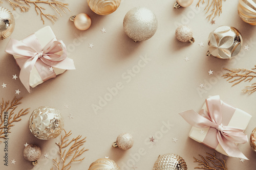 Christmas banner. Beige Xmas background with golden balls, decorative branches, gift boxes. Christmas frame, greeting card template, web banner mockup. Flat lay, top view, copy space