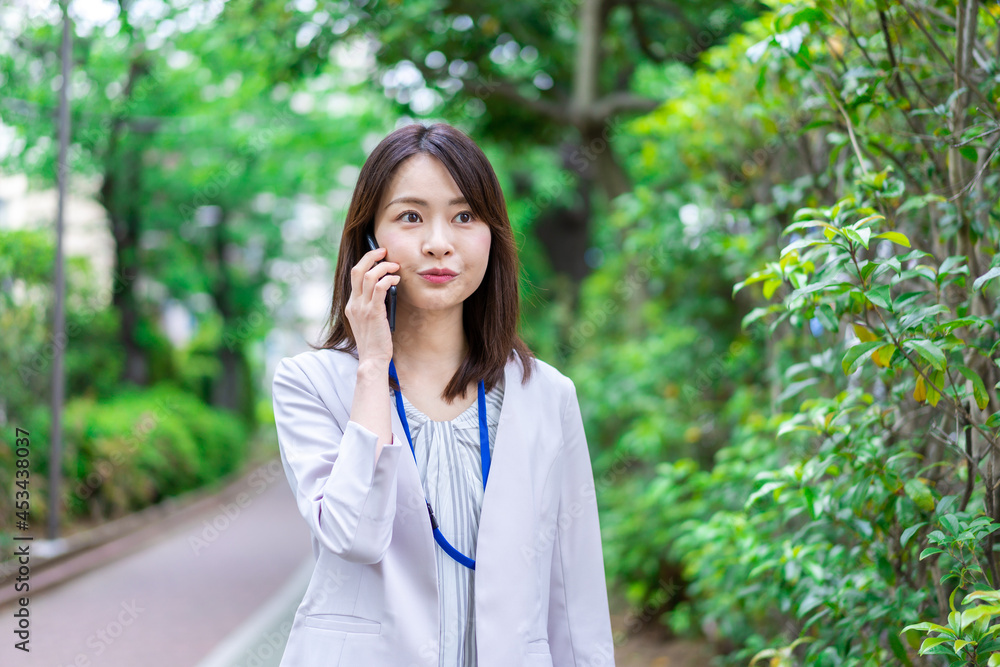 外で電話をするビジネスウーマン