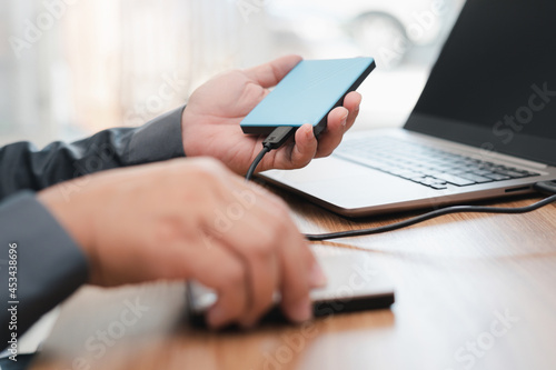 External backup disk in hard a man connected to laptop computer safety personal data copy Prevent data corruption in the computer system