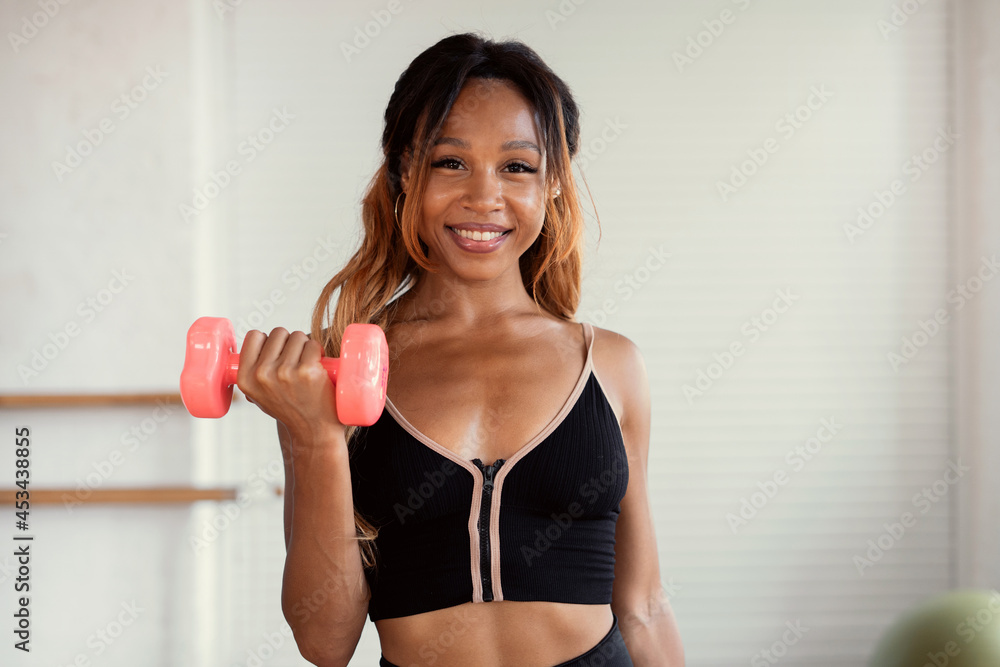 Active exercises on the cardio system with dumbbells. A sporty female trainer trains one in a bright fitness studio. A healthy lifestyle and fortitude. Active exercises on the cardio system with dumbbells. A sporty female trainer trains one in a bright fitness studio. A healthy lifestyle and fortitude.