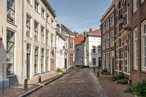 Zwolle, The Netherlands, August 9, 2021: street in the old town with traditional houses and brick and plaster facades.