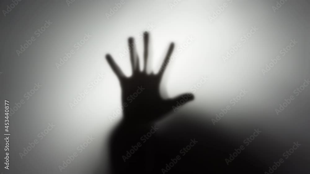 4k video of a silhouette of a man's hand behind a translucent glass. The concept of the other world, victims of violence, paronormal, ghosts. 4k video of a silhouette of a man's hand behind a translucent glass. The concept of the other world, victims of violence, paronormal, ghosts.