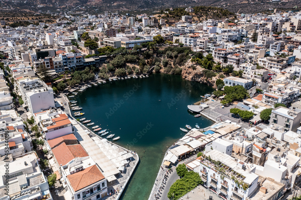 panoramic view of the Cretan city with white houses on the embankment near the sea filmed from a drone 