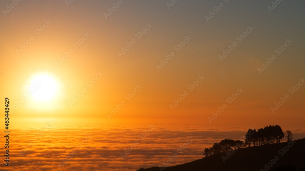 Sun setting over an inversion cloud layer