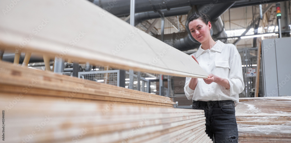 Business woman worker in the carpentry factory using tablet pc. Carpentry factory. Factory for the production of parquet board