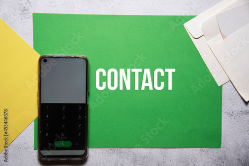 Contact text on green and yellow background flat lay concept. photo