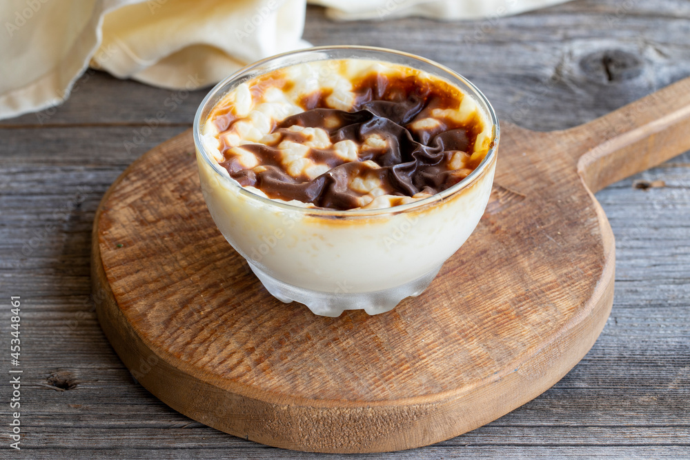 Rice pudding on wood floor. Rice pudding is a dessert made with rice and milk. Rice pudding on wood floor. Rice pudding is a dessert made with rice and milk.