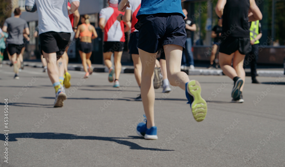 Legs of athletes running marathon in city