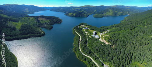 Panoramic view above Vidra Lake. The lake is located in a mountainous area, surrounded by coniferous forests. Vidra resort is built near the lake. Carpathia, Romania. 