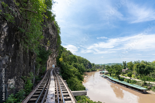 The railway at the foot of the mountain, next to the river and blue sky : Tham Krasae, Kanchanaburi Province landmark of Thailand location