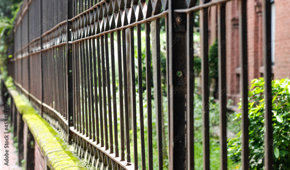 Old rusty iron fence beside the road close up with selective focus Old rusty iron fence beside the road close up with selective focus