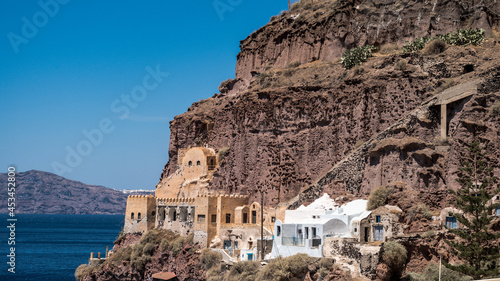Old port of Thira on Santorini island in Greece. Aegean sea. Sunny day. Ancient architecture building in rock. photo